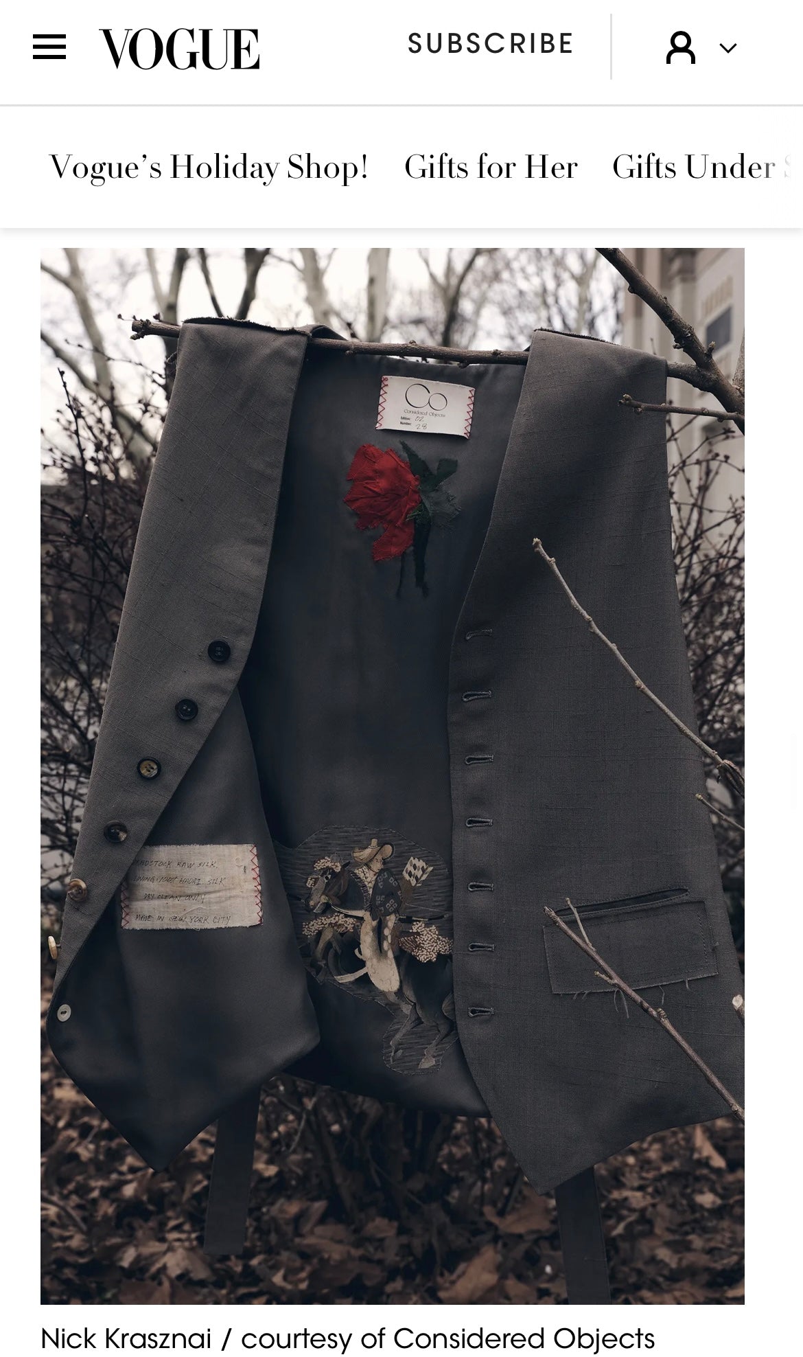 A dark charcoal gray vest from Considered Objects with a pressed red flower, made from vintage silk kimono textiles.  