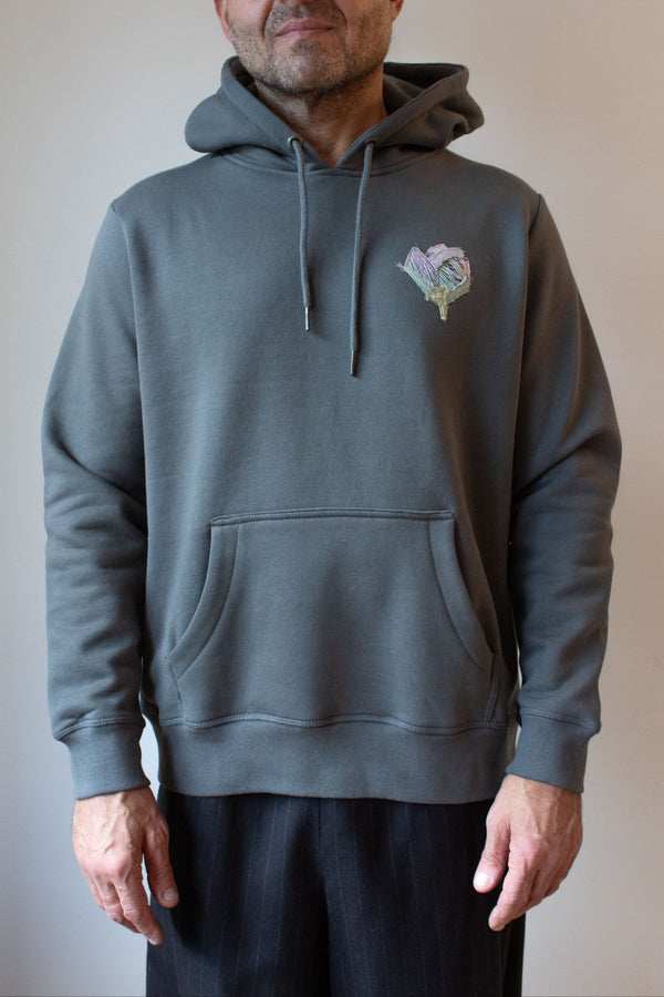 Man wearing a gray hoodie with a floral design on a plain background