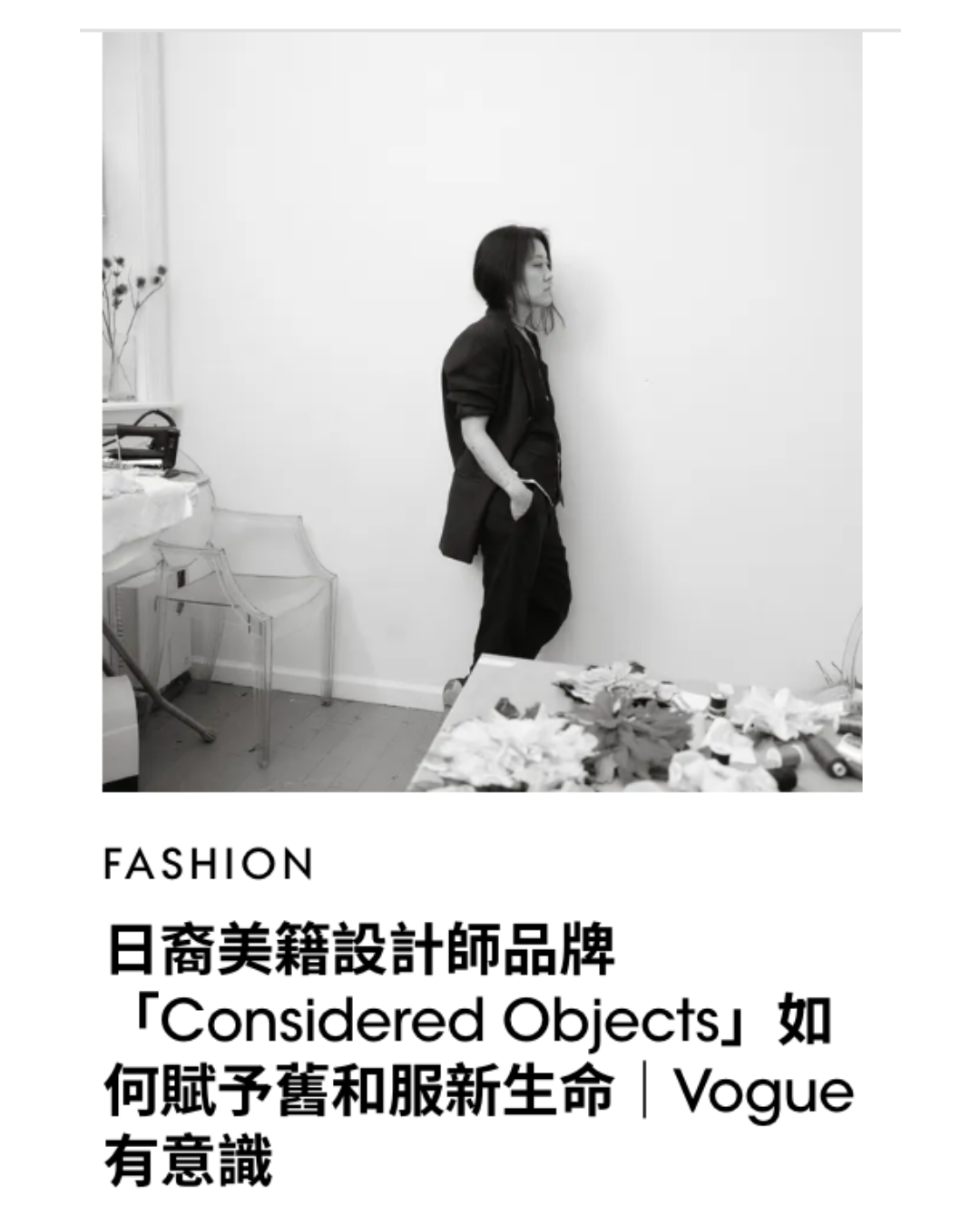 A black-and-white editorial-style photo shows a woman standing in a minimalist room with a desk and chair, with large Chinese text below reading 'FASHION' and '日裔美籍設計師品牌 Considered Objects 如何賦予舊服新生命 | Vogue 有意識'.